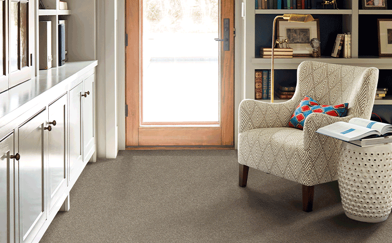 grey carpet in living room with comfy statement chair